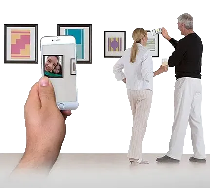 Gallery visitors viewing AR content overlaid on framed artwork through a phone.